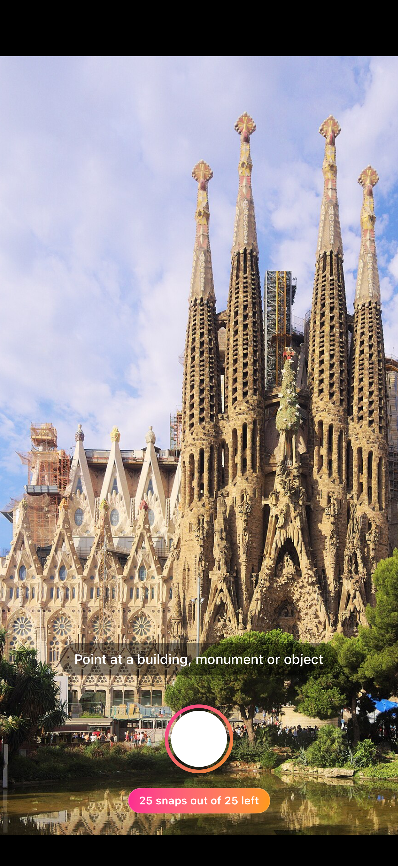 Naruho's camera viewfinder pointed at the Sagrada Família, with the brand-coloured shutter and snap counter visible